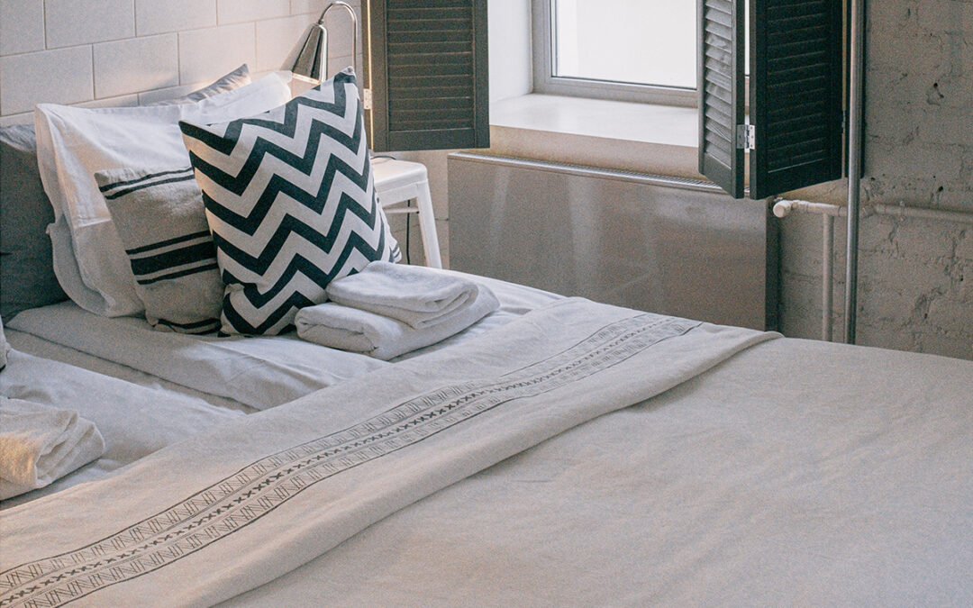 minimalistic decor in guest bedroom with white linen and black and white decor pillow in los angeles home_Mortgage Capital Partners